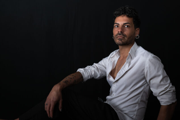 Ritratto di un modello con abbigliamento casual, posato in sala pose con sfondo nero e illuminazione soft, foto di Piero Fattizzo