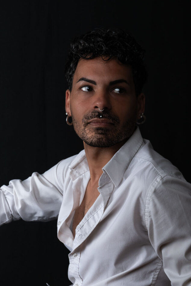 Ritratto di un modello con abbigliamento casual, posato in sala pose con sfondo nero e illuminazione soft, foto di Piero Fattizzo