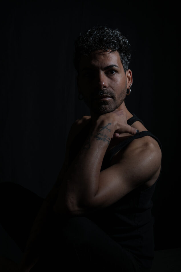 Modello in posa per un ritratto fotografico in studio, utilizzando illuminazione professionale e uno sfondo nero per un effetto elegante, fotografato da Piero Fattizzo