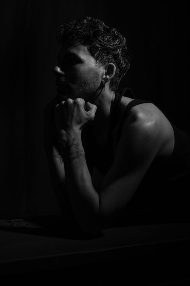 Modello in posa per un ritratto fotografico in studio, utilizzando illuminazione professionale e uno sfondo nero per un effetto elegante, fotografato da Piero Fattizzo